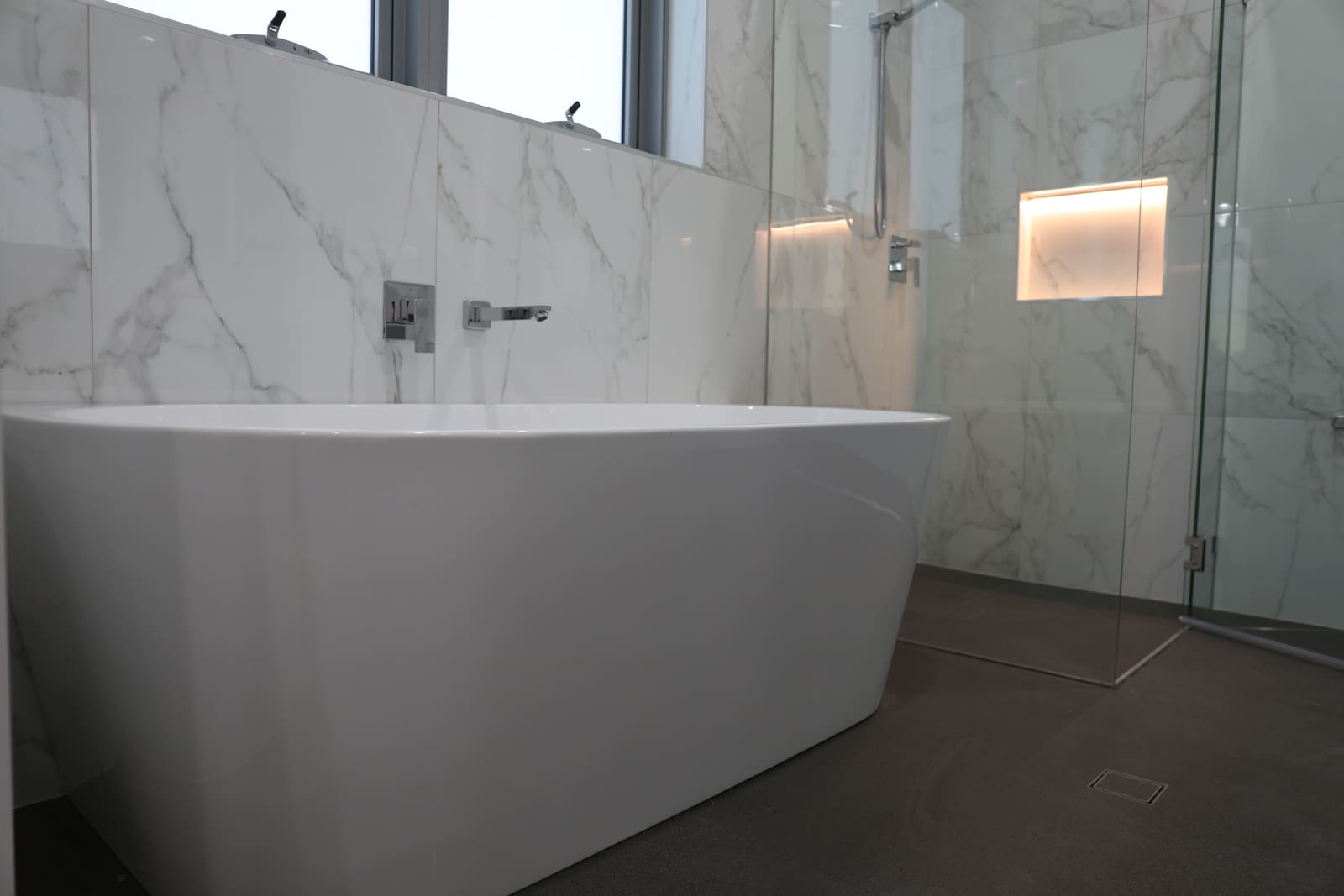 Freestanding bath in a marble-tiled bathroom