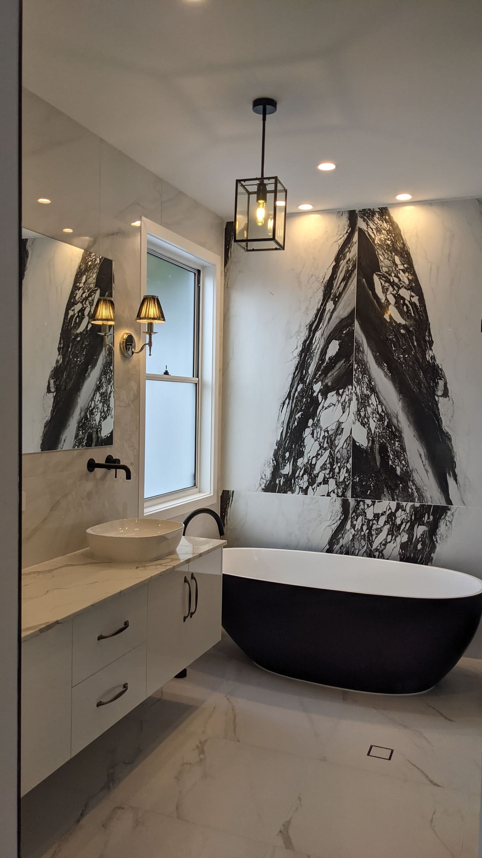Bathroom with a freestanding bath and marble feature wall