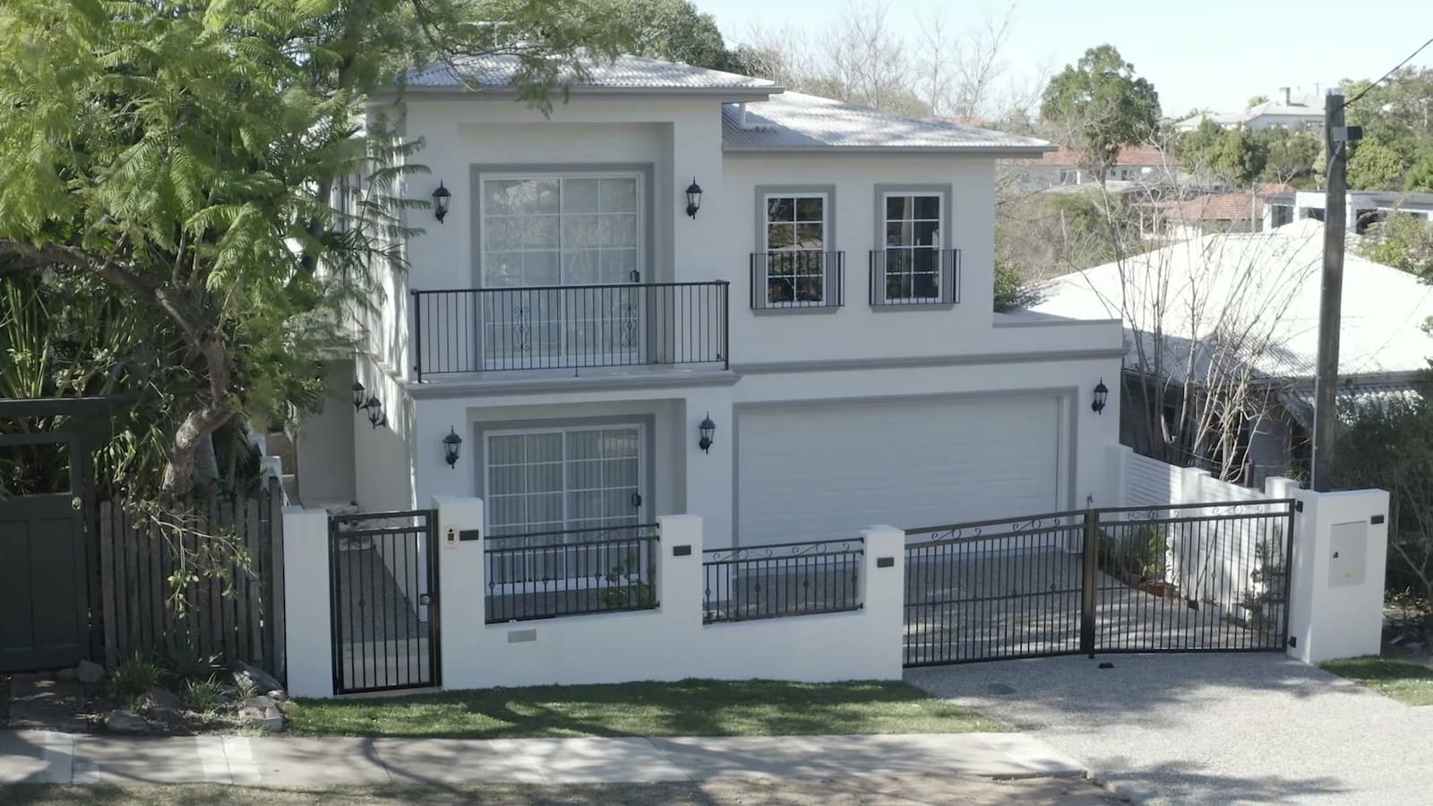 Two-storey facade behind a rendered front fence