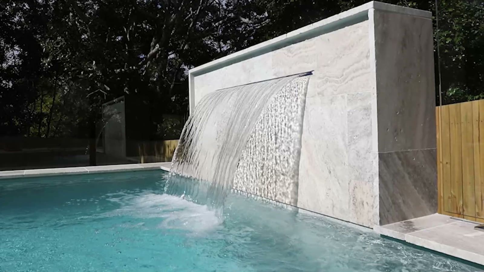Pool with a stone waterfall wall