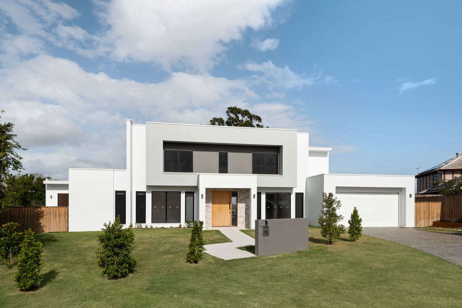 White two-storey facade across the front lawn