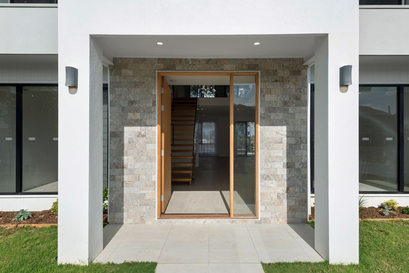 Stone-clad entry with a timber pivot door