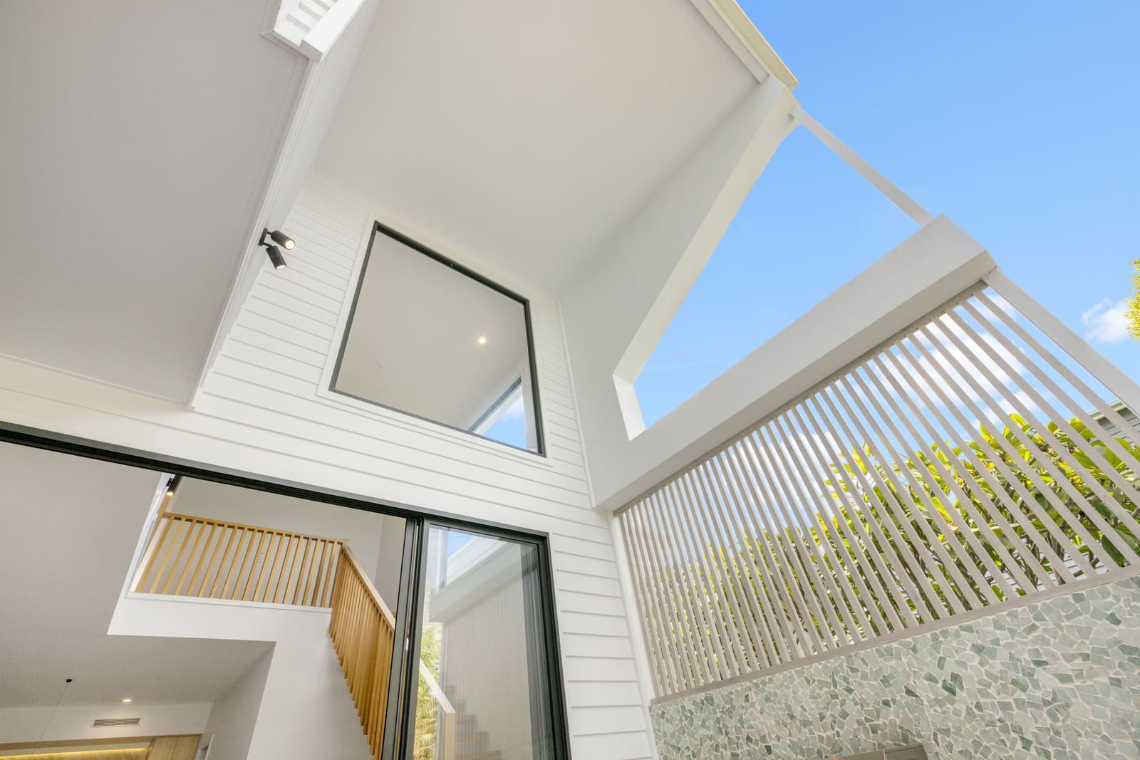 Angled white facade and batten screen against the sky