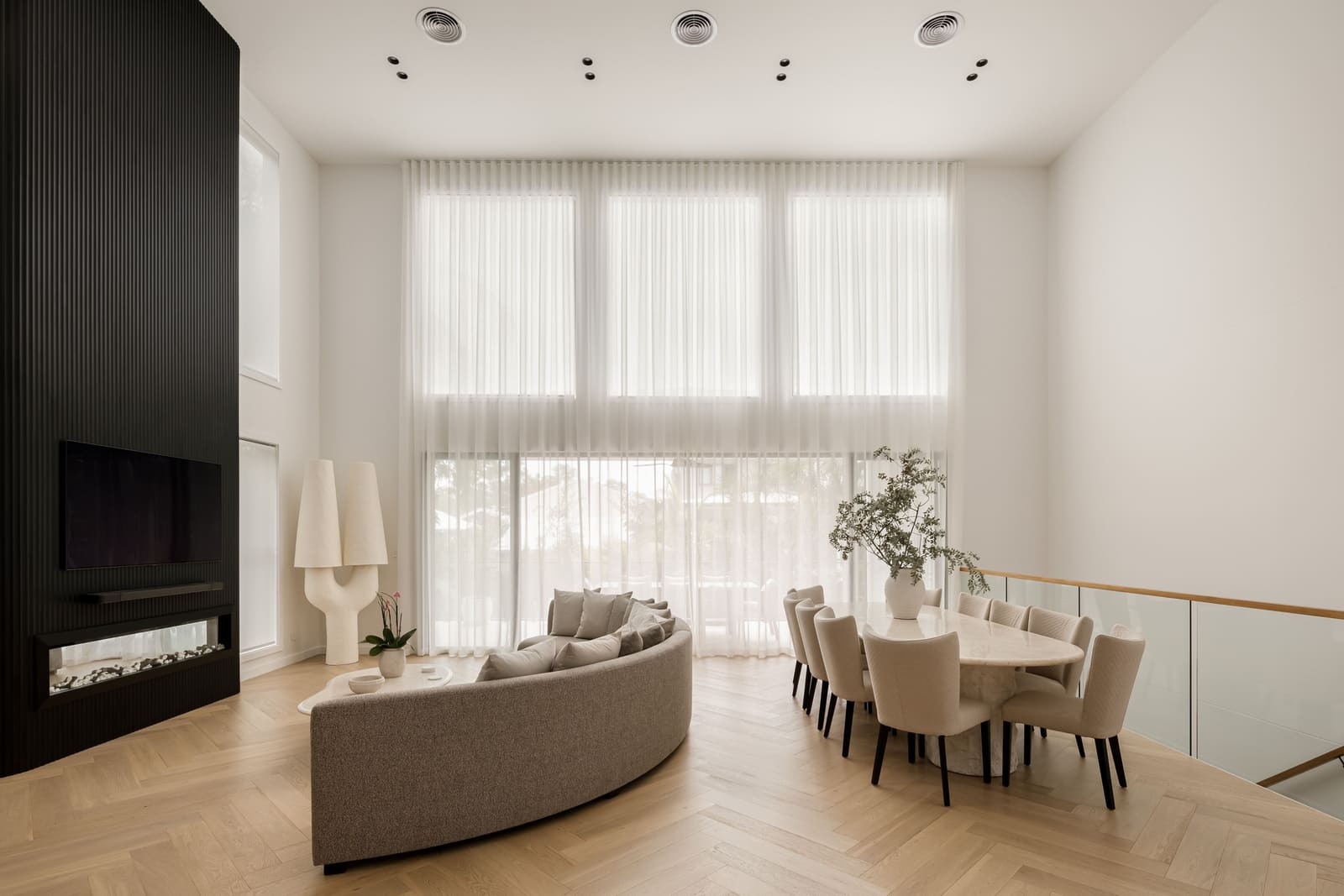 Double-height living room with a linear fireplace wall