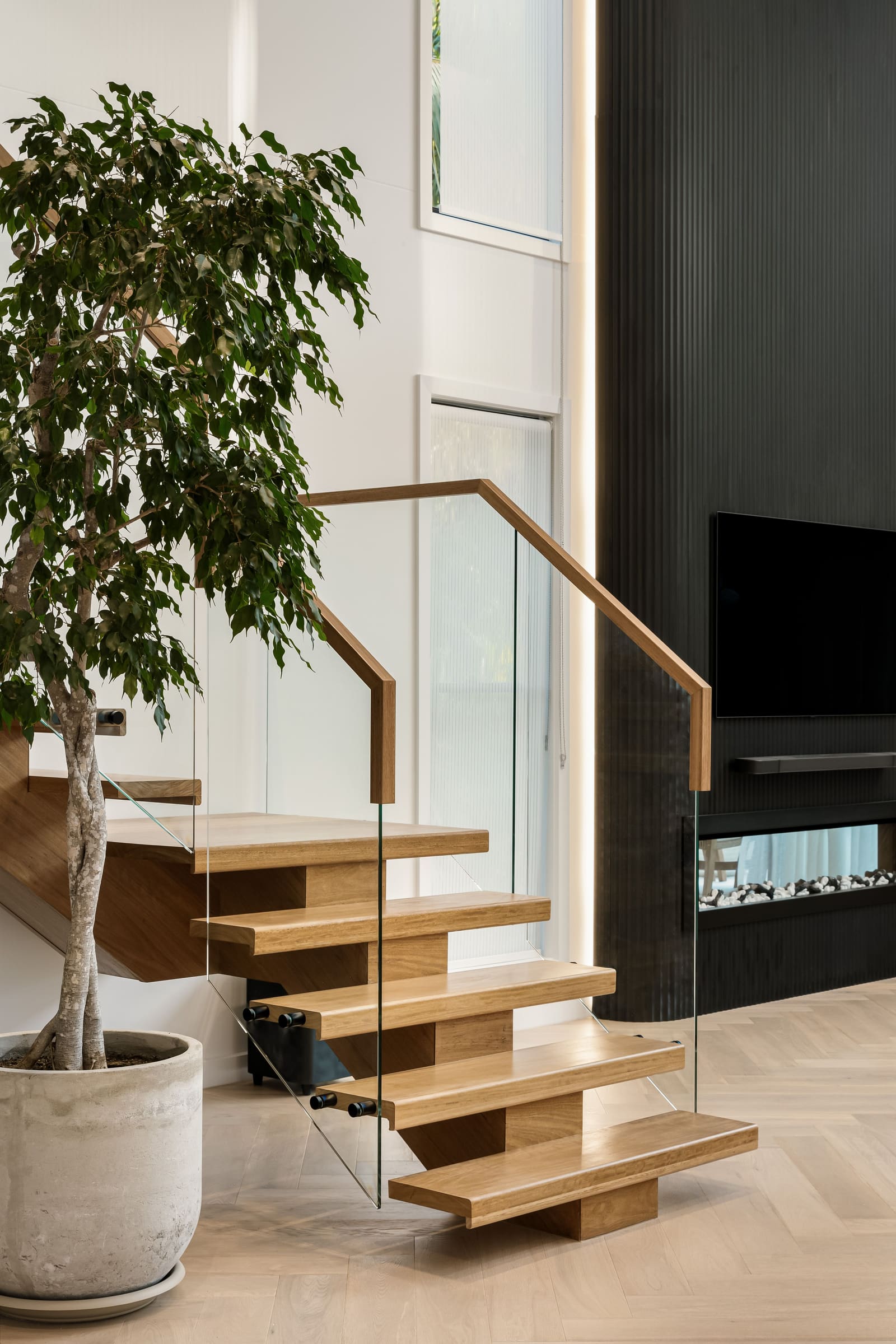 Floating timber stair beside the fireplace