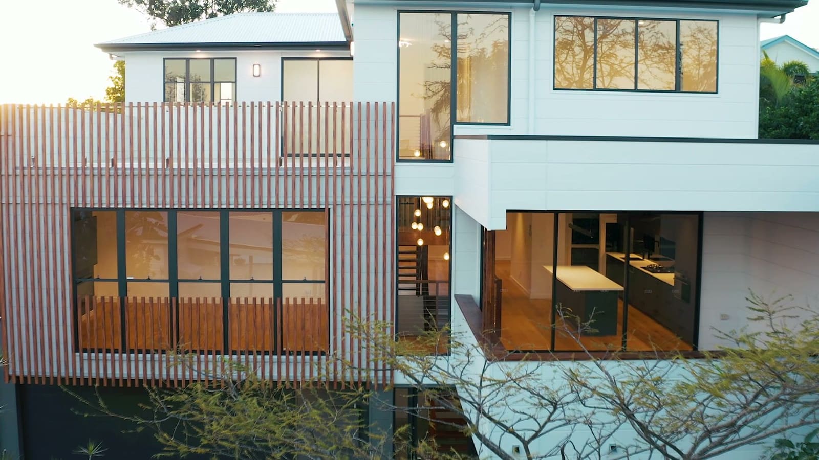 Rear facade with timber battens, lit at dusk