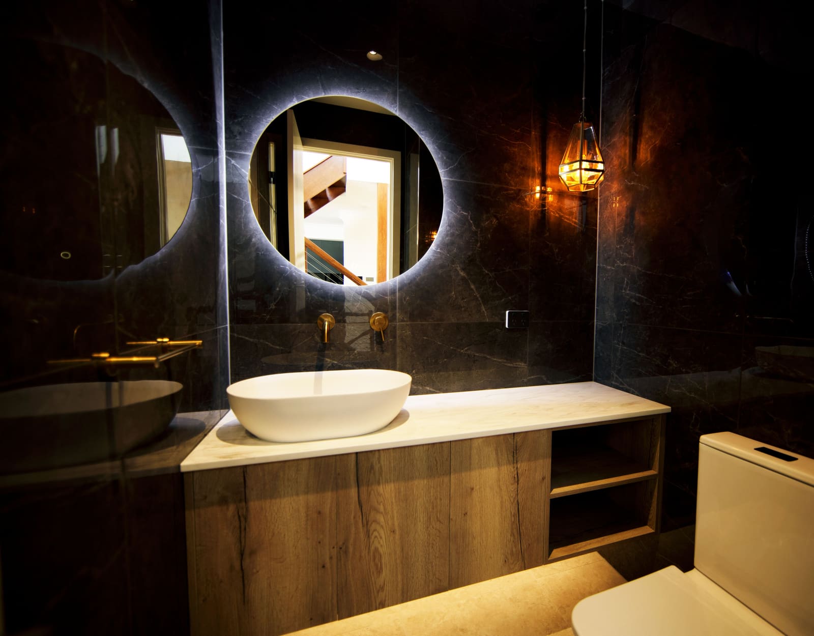 Powder room with a backlit round mirror